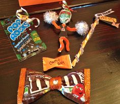 some candy and candies are sitting on a table next to an orange bow tie