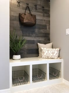 a bench with some baskets and a bag hanging on the wall