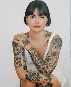 a woman with tattoos on her arms and chest