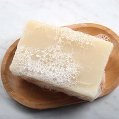 two pieces of soap sitting on top of a wooden plate