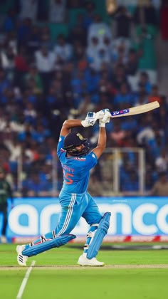 a man swinging a cricket bat on top of a field