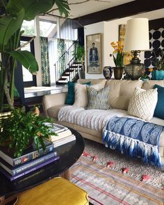 a living room filled with lots of furniture and plants on top of a coffee table