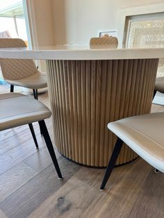 two chairs sitting in front of a table with a white counter top and wooden paneling