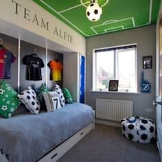 a bedroom with a soccer theme painted on the ceiling and bed in the corner,