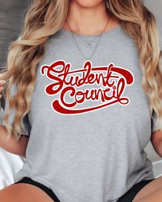 a woman wearing a grey shirt with the words student council printed in red on it