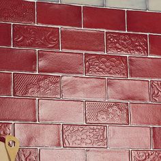 a red brick wall with a pair of scissors next to it and a cutting board