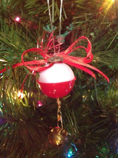 a red and white ornament hanging from a christmas tree