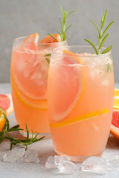 two glasses filled with grapefruit lemonade and rosemary garnish