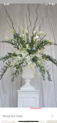 a white vase filled with flowers on top of a table