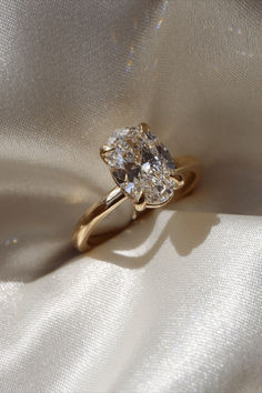 a diamond ring sitting on top of a white cloth