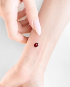 a ladybug tattoo on the left wrist