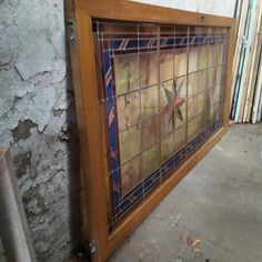 an old stained glass window with wooden frame