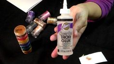 a person is holding a small bottle of glue