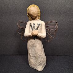 a ceramic figurine of a woman with wings and fern leaves on her chest