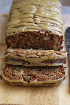 sliced loaf of cake sitting on top of a cutting board next to a knife