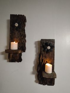 two wooden wall sconces with candles on them