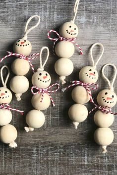 six snowman ornaments hanging from string on wooden table