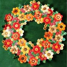 a wreath made out of flowers on a green background