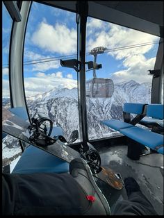 a ski lift with snow covered mountains in the background