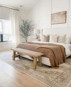 a bedroom with white walls and wooden floors