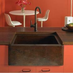 a kitchen with an orange wall and sink