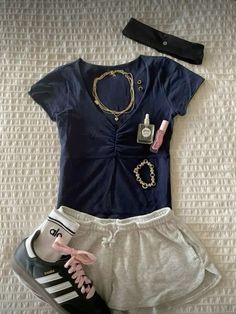 a pair of shorts and sneakers are laid out on the bed next to a t - shirt