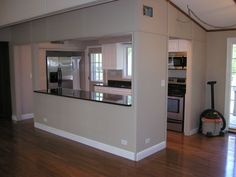 an empty kitchen and living room with hard wood floors