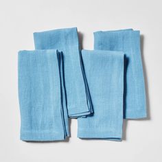 four blue linen napkins folded on top of each other