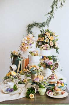 a table topped with lots of different types of cakes and desserts covered in flowers