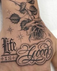 a hand with a rose on it and the words life is good written in cursive writing