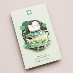 a pin with a bird in a teacup on it