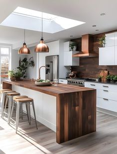 an open kitchen with white cabinets and wooden counter tops, along with bar stools