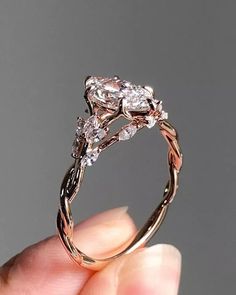 a person is holding an engagement ring with two diamonds on it's sides and the top