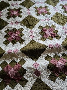 a quilt with pink and green flowers on it