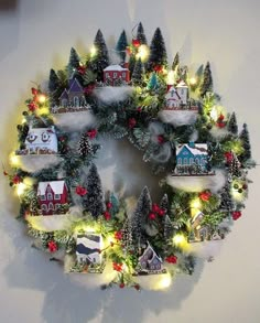 a christmas wreath with lights and houses on it