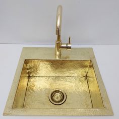 a gold sink with a faucet on the side and a drain in the middle