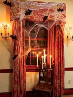 a room decorated for halloween with spider web and candles