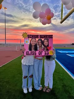 two girls holding up a sign that says senior sunrise class of 2013