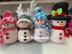 several knitted snowmen with hats and scarves