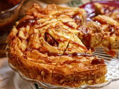 a pie with caramel sauce on it sitting on a glass plate