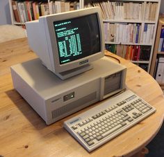 an old computer sitting on top of a wooden table