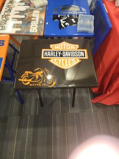 there is a harley davidson coffee table on the floor next to other tables and chairs