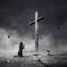 a woman kneeling down in front of a cross with birds flying around her on a cloudy day