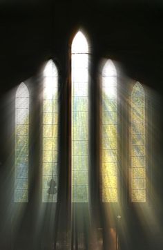 sunlight streaming through three windows in a church