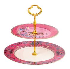 two tiered tray with pink and gold plates on it, each holding a golden handle