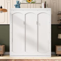 a white cabinet with three doors in the middle of a room next to a lamp