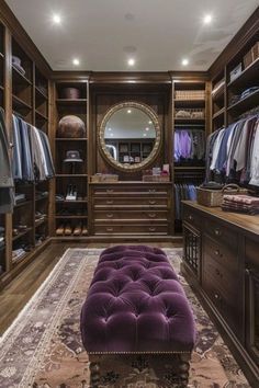 a walk - in closet with purple tufted bench and large mirror on the wall