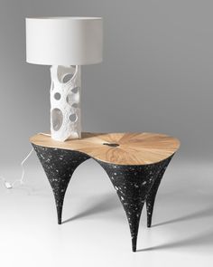 a table with a lamp on top of it next to a wooden stand that has circles and dots on it