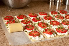 there is a tray of appetizers with tomatoes on it and cheese in the middle