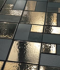 a black and gold tiled floor with water drops